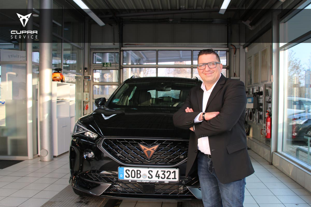 Mitarbeiter steht vor einem Cupra.