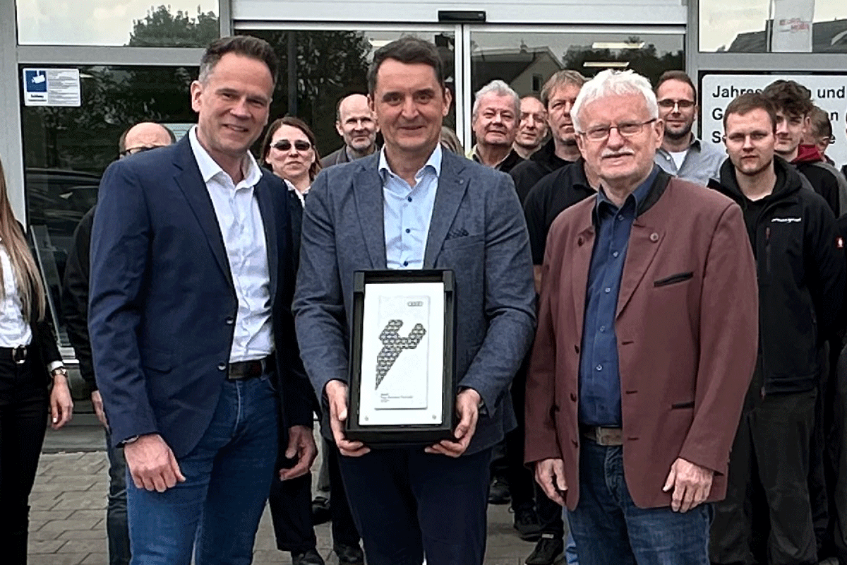 Audi-Vertriebspartner-Betreuer After Sales Axel Freye, Betriebsleiter Michael Götz und noch ein weiterer MItarbeiter stehen mit der Auszeichnung vor unserem AUtohaus in Hilpoltstein.
