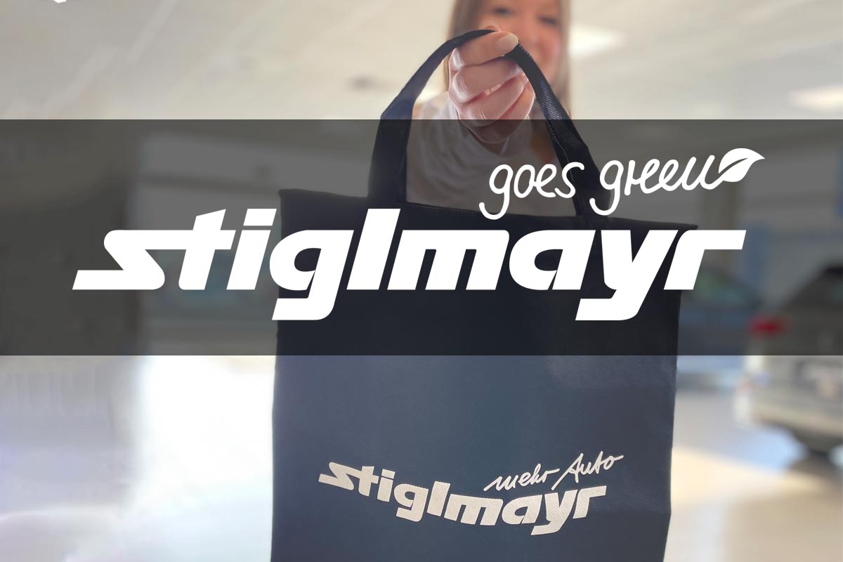 Bild zeigt das Logo Stiglmayr goes green mit der Stiglmayr-Stofftasche im Hintergrund.