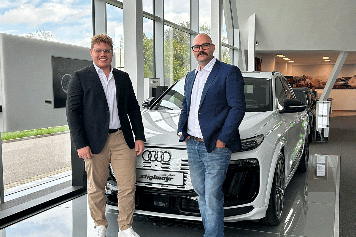 Zwei Großkundenverkäufer stehen vor einem weißem Audi in unserem Audi Terminal in Paffenhofen.