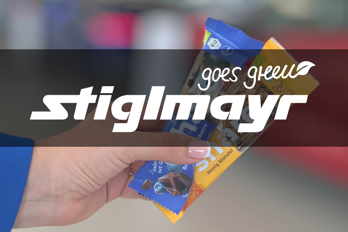 Bild zeigt das Logo Stiglmayr goes green mit dem Share Müsliriegel im Hintergrund.