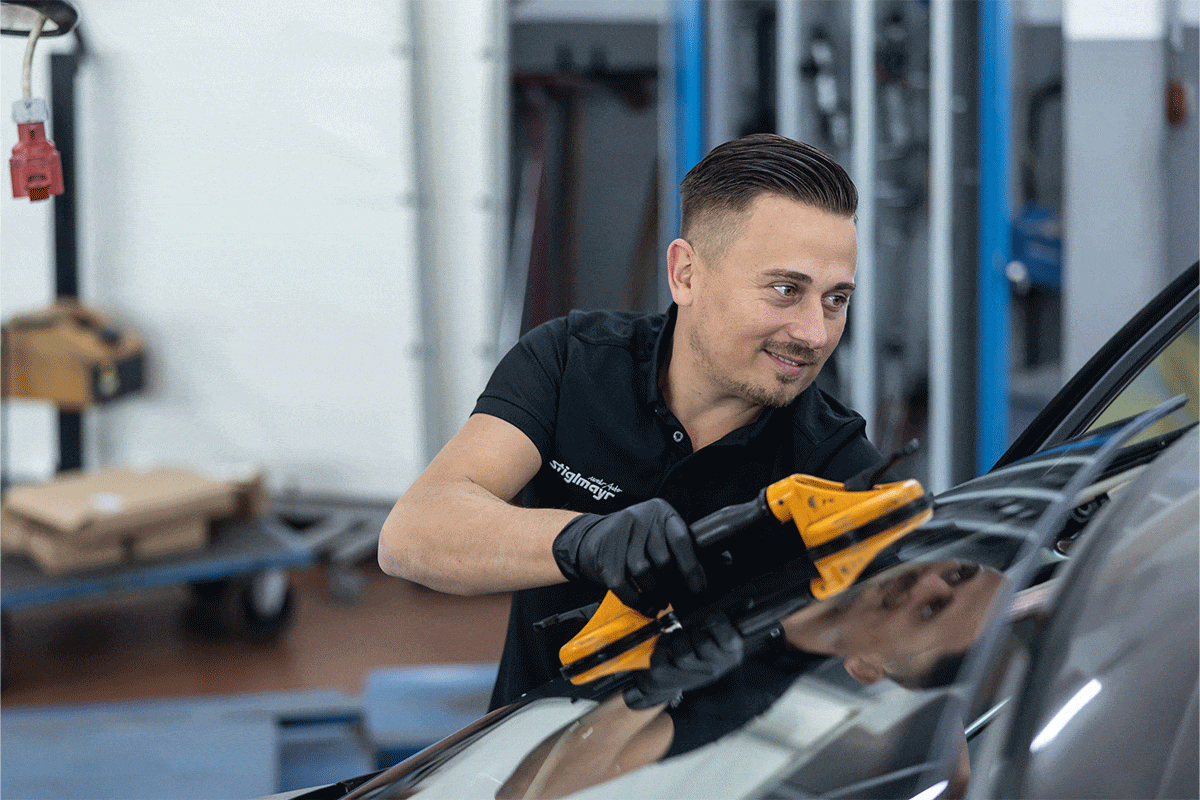 Ein Mitarbeiter ist bei der Fahrzeuginstandsetzung in der Werkstatt.