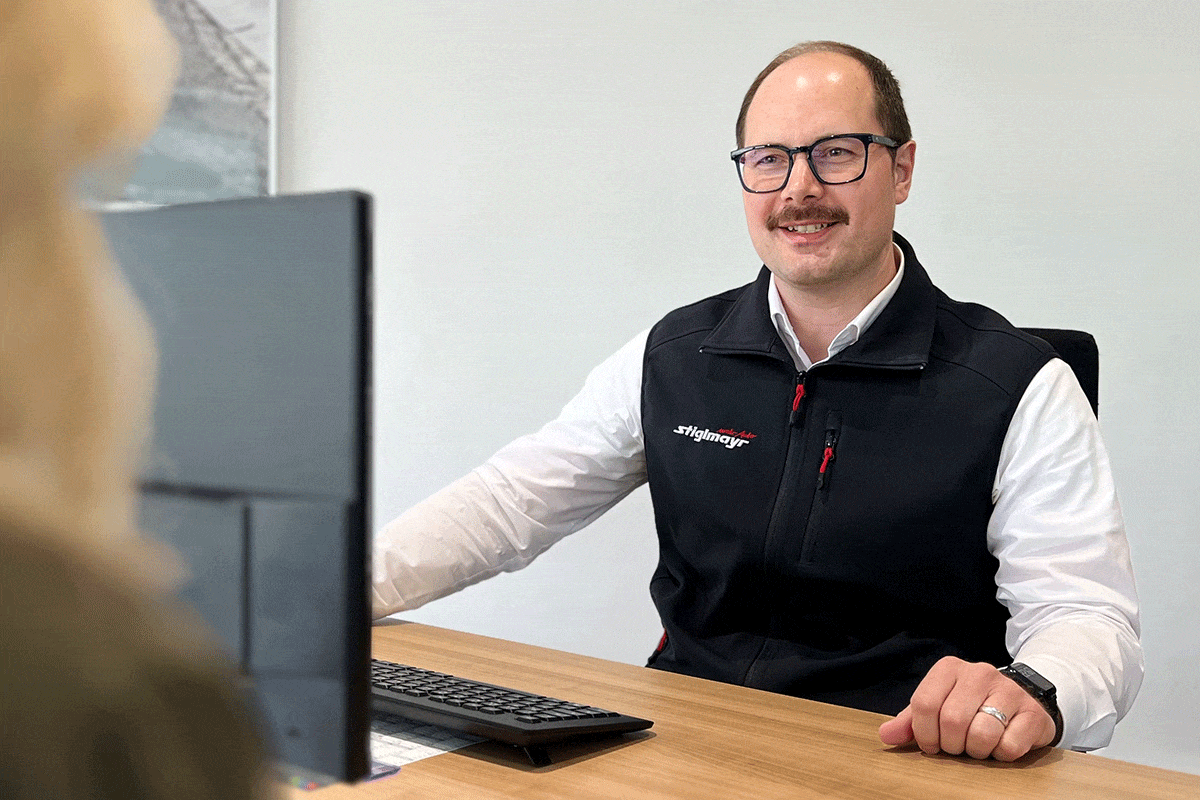 Ein Mitarbeiter sitzt mit einem Kunden am Tisch und führt ein Gespräch.
